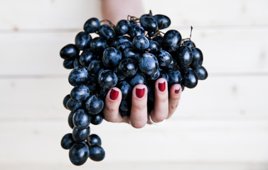 Sweet tasty grapes in graceful woman's hand