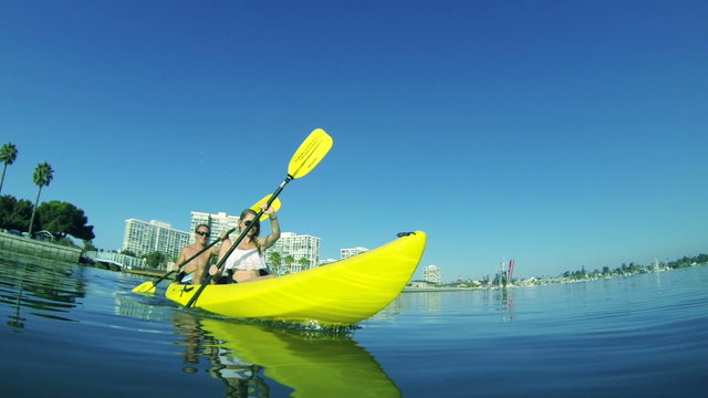 Slow Motion Young Couple Kayaking Outside In Ocean