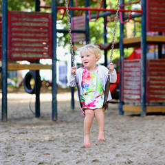 Little girl swinging at playground