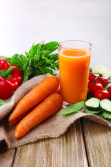 Glass of fresh carrot juice and vegetables