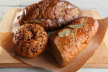 Fresh baked bread, on cutting board, on wooden background
