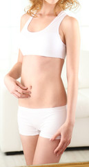 Beautiful woman with slim body posing near mirror in room