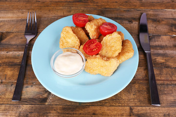 Chicken nuggets with sauce on table close-up