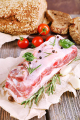 raw bacon with bread and spices on wooden table