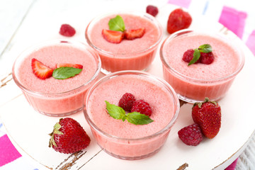 Delicious berry mousse in bowls on table close-up