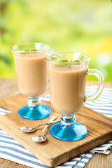 Delicious berry mousse in glasses on table on bright background