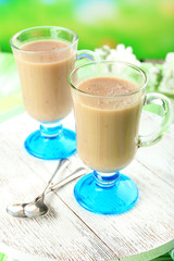 Delicious berry mousse in glasses on table on bright background