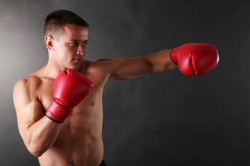 Fototapeta na wymiar Handsome young muscular sportsman with boxing gloves
