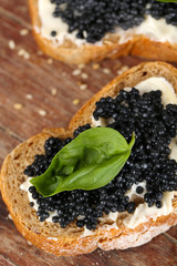 Slices of bread with butter and black caviar