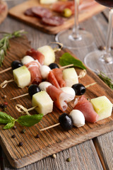 Delicious melon with prosciutto on table close-up