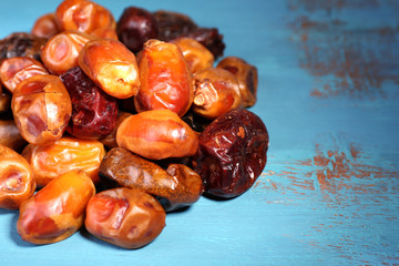 Tasty dates fruits on blue wooden table