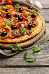 Delicious pizza served on wooden table