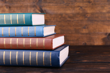 Books on wooden table on wooden wall background