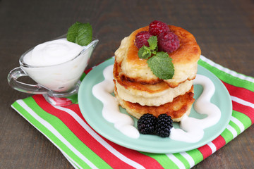 Tasty pancakes with fresh berries, cream and mint leaf