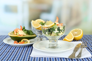 Tasty salads with shrimps and avocado in glass bowl and