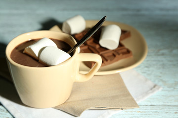 Hot chocolate with marshmallows in mug, on wooden background