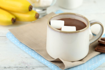 Hot chocolate with marshmallows in mug, on wooden background