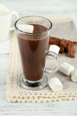 Chocolate drink with marshmallows in mug, on wooden background