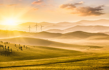 Obraz premium Mountains and grassland at sunset