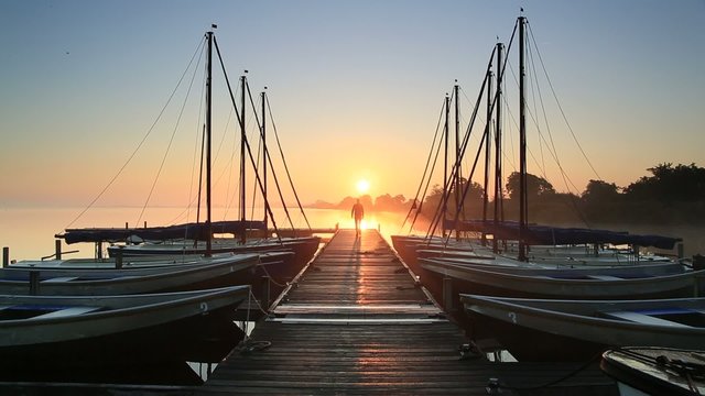 Walking on a jetty during sunrise.