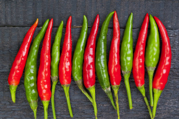 Red and green pepper on wooden background