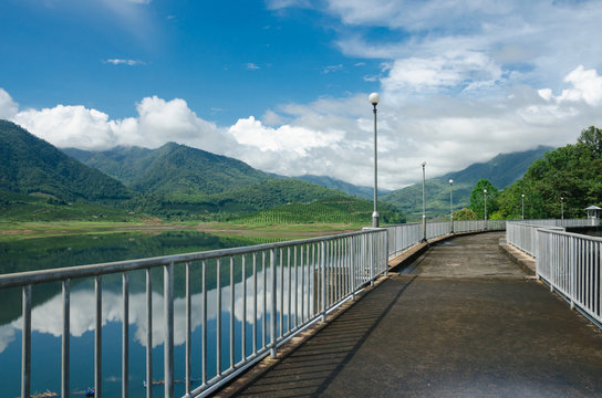 Cement way on top of dam with nature view