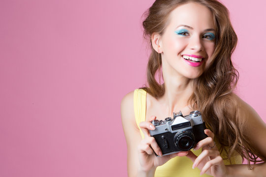 Young beautiful girl holding a camera in vintage style depicted 