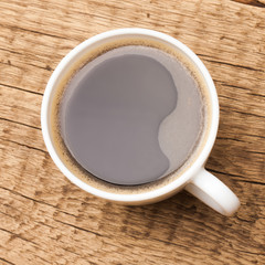 Coffee in white ceramic cup on wooden table - 1 to 1 ratio