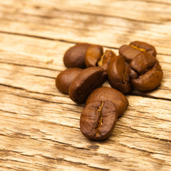 Roasted coffee beans on old wooden table - 1 to 1 ratio