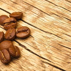 Roasted coffee beans on old wooden table - 1 to 1 ratio