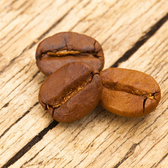 Roasted coffee beans on old wooden table - 1 to 1 ratio