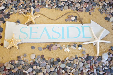 Seaside sign on beach background