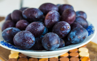 fresh juicy plums on a white board