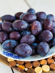 fresh juicy plums on a white board