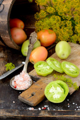 Different varieties of tomatoes on wooden background.