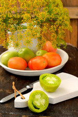 Different varieties of tomatoes on wooden background.