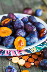 raw blue plum slices on a wooden board