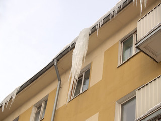 Icicles dangerously hang down from a roof