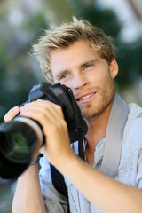 Young photographer shooting with digital camera