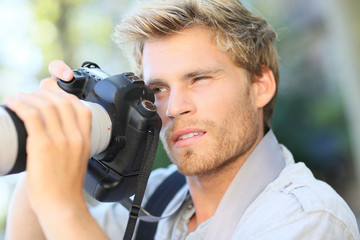 Young photographer shooting with digital camera