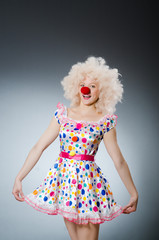 Clown with white wig against grey background