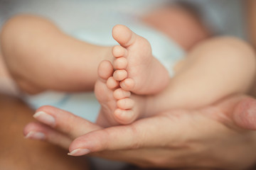 Newborn baby feet in mother hands.