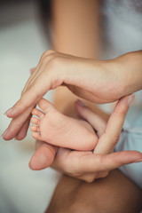 Obraz na płótnie Canvas Newborn baby feet in mother hands.