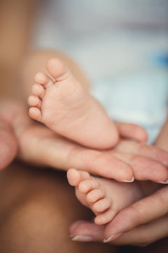 Newborn baby feet in mother hands.