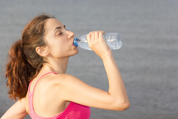 Athlete woman drinking water outdoors
