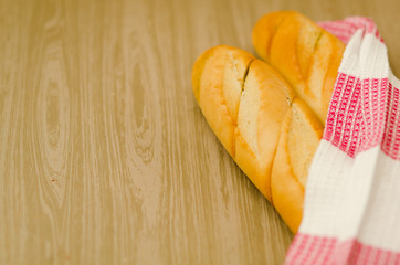 Свежий горячий хлеб, обернутый в вафельное цветное полотенце