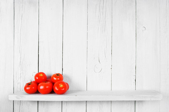 Tomatoes on a wooden shelf.