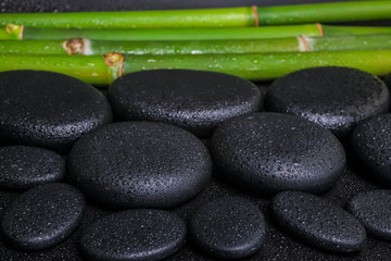 spa concept of zen basalt stones and bamboo with dew, closeup