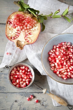 pomegranate with branch and grains on bowl and strainer