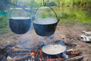 gotowanie posiłku na ognisku w metalowych naczyniach 